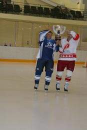 Максим Шкадов, капитан команды - победителя турнира, принимает кубок из рук легенды советского хоккея Александра Якушева